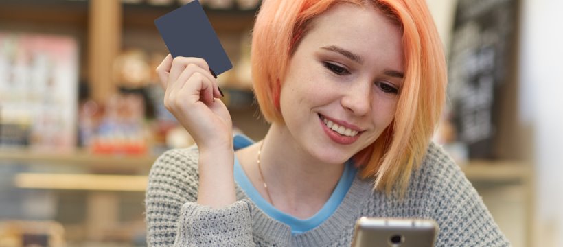 Teenage girl with debit card and phone