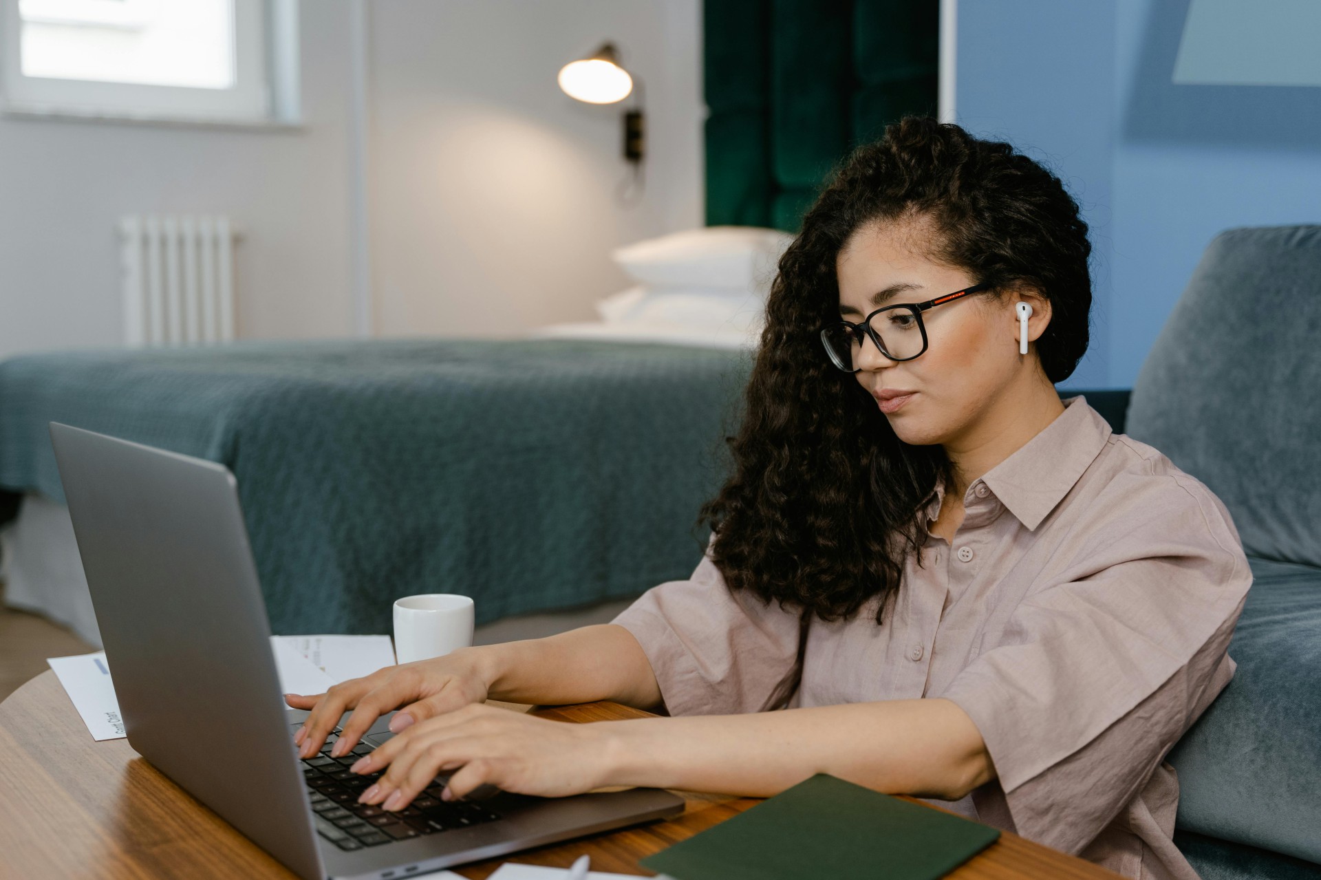 Woman typing on a laptop for an online meeting.